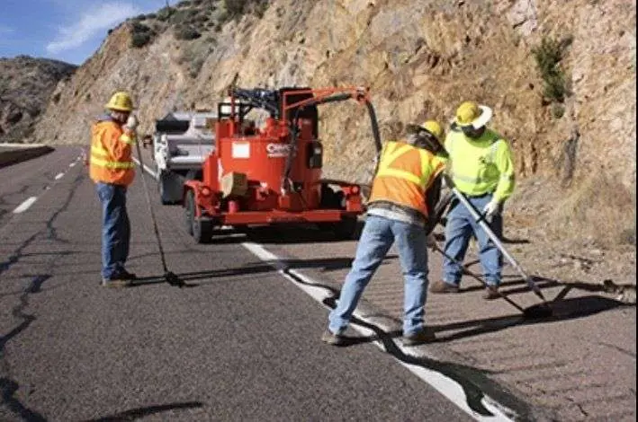 A CAP crew running a Crafco hot-jacketed melter on a highway crack-seal job.