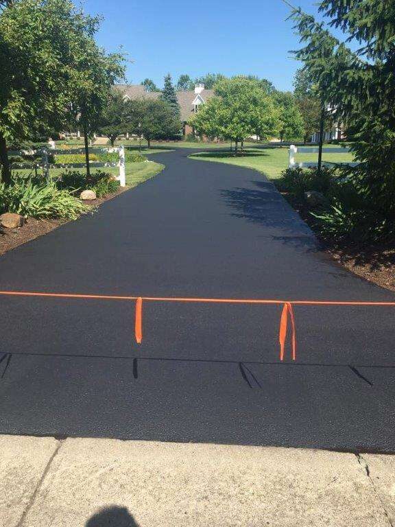 Residential driveway, freshly sealed and marked off to cure.