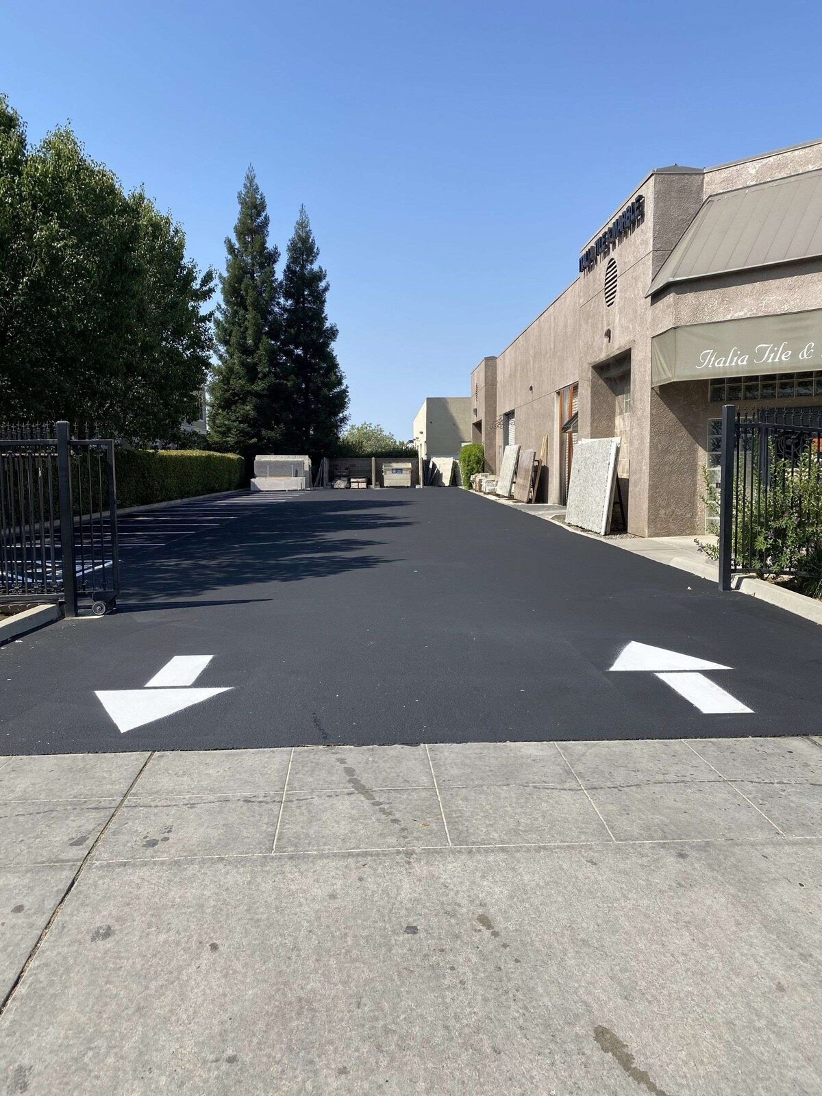 Directional arrows on a fresh-sealed commercial alley.